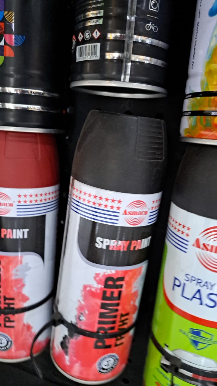 Collection of Asmaco spray paint cans with visible labels on a dark background