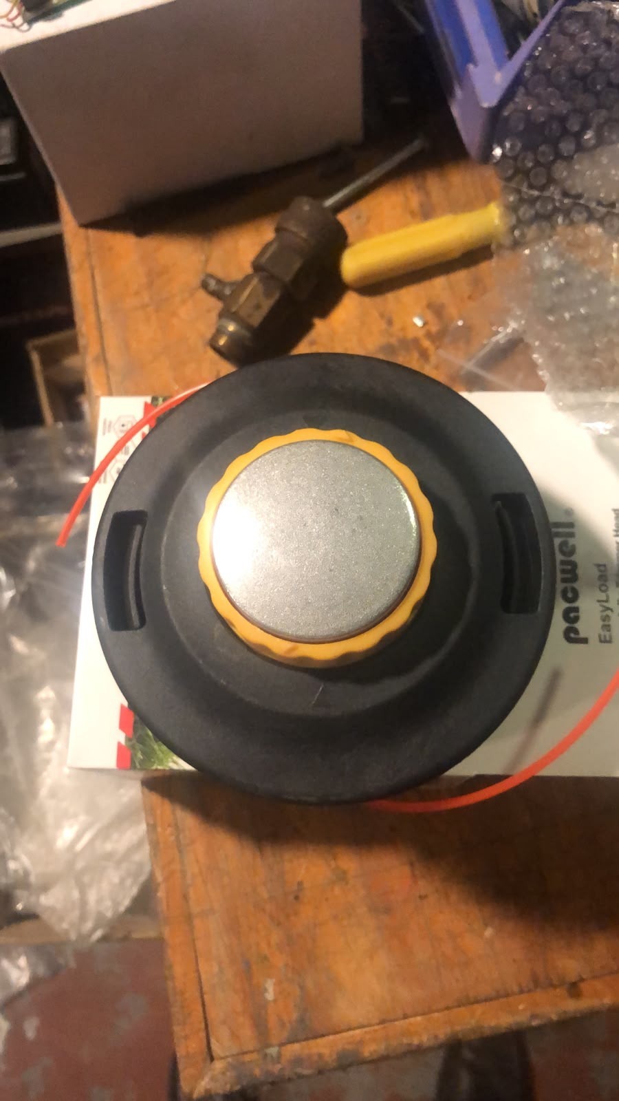 Pacwell round black trimmer head with a silver centre, yellow trim and red cutting line