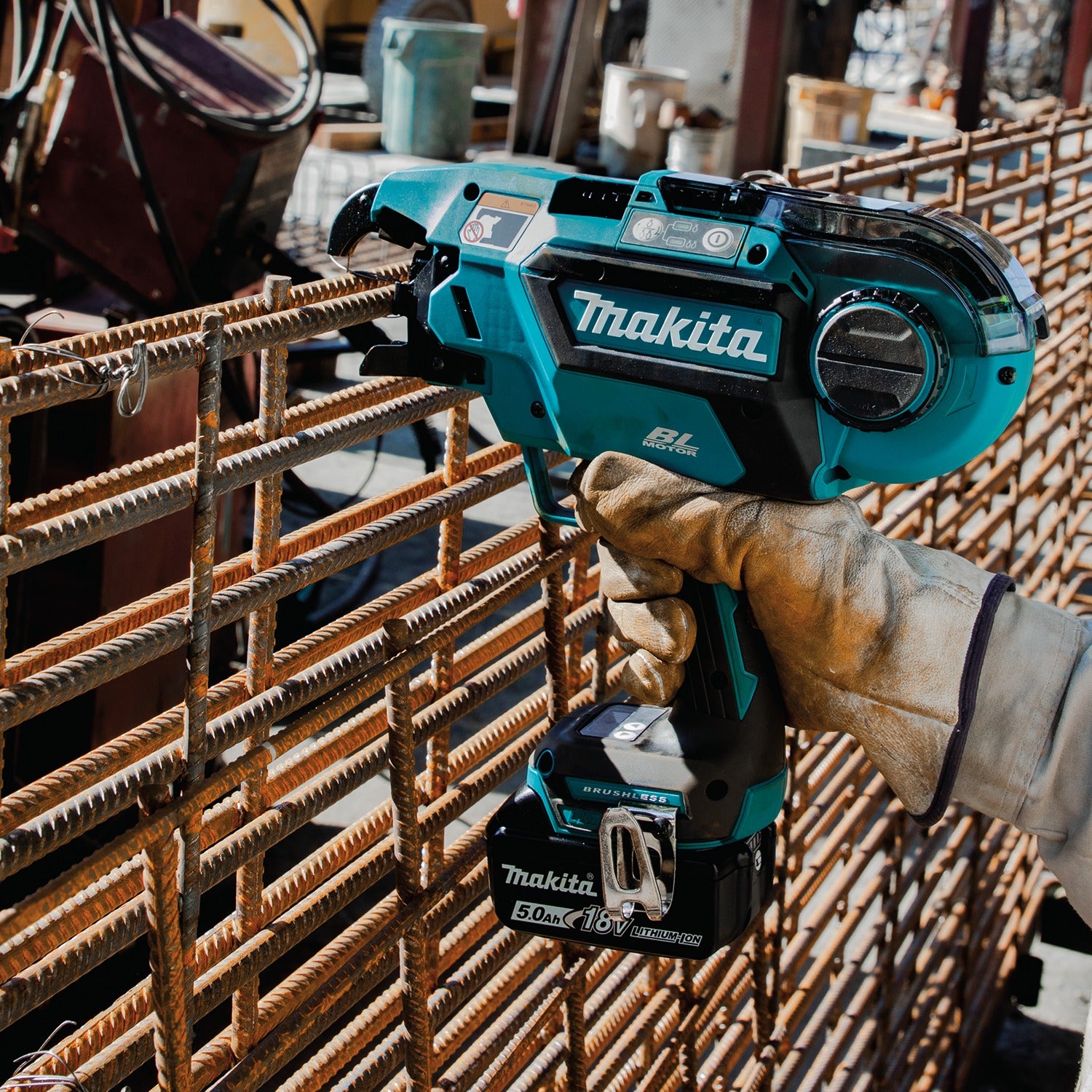 Person using a Makita cordless rebar tying tool on metal rebar 