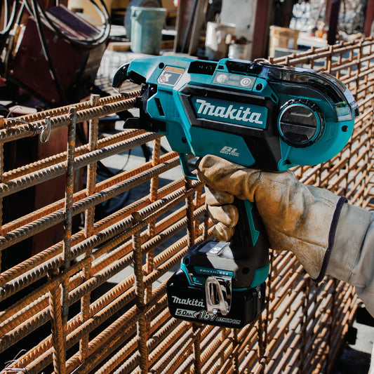 Person using a Makita cordless rebar tying tool on metal rebar 